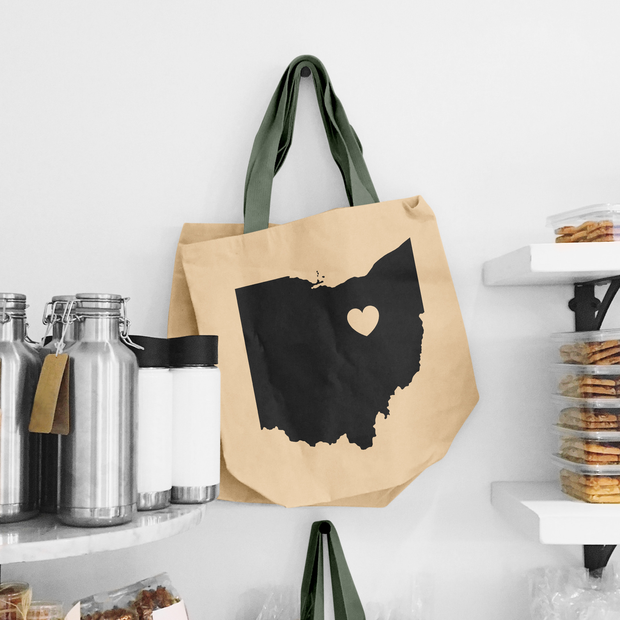 Black illustration of map of Ohio on the beige shopping bag with dirty green handle.