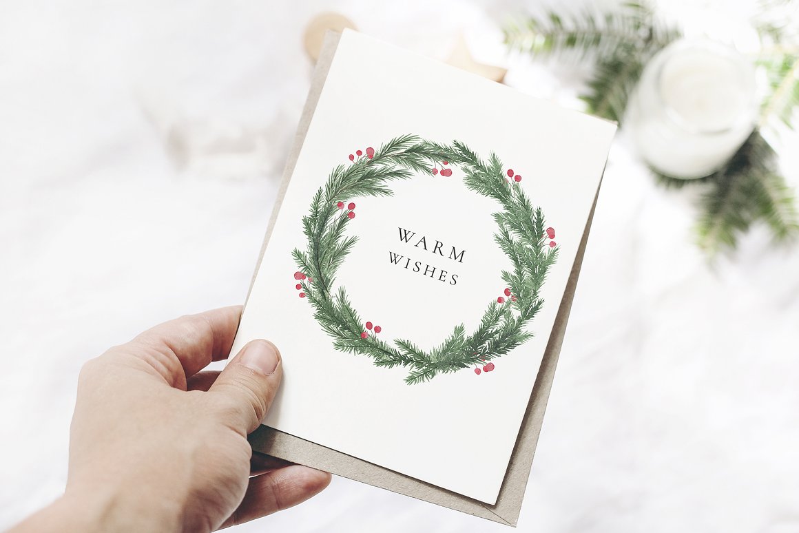 White greeting card with black lettering "Warm wishes" on the cantre of floral wreath.