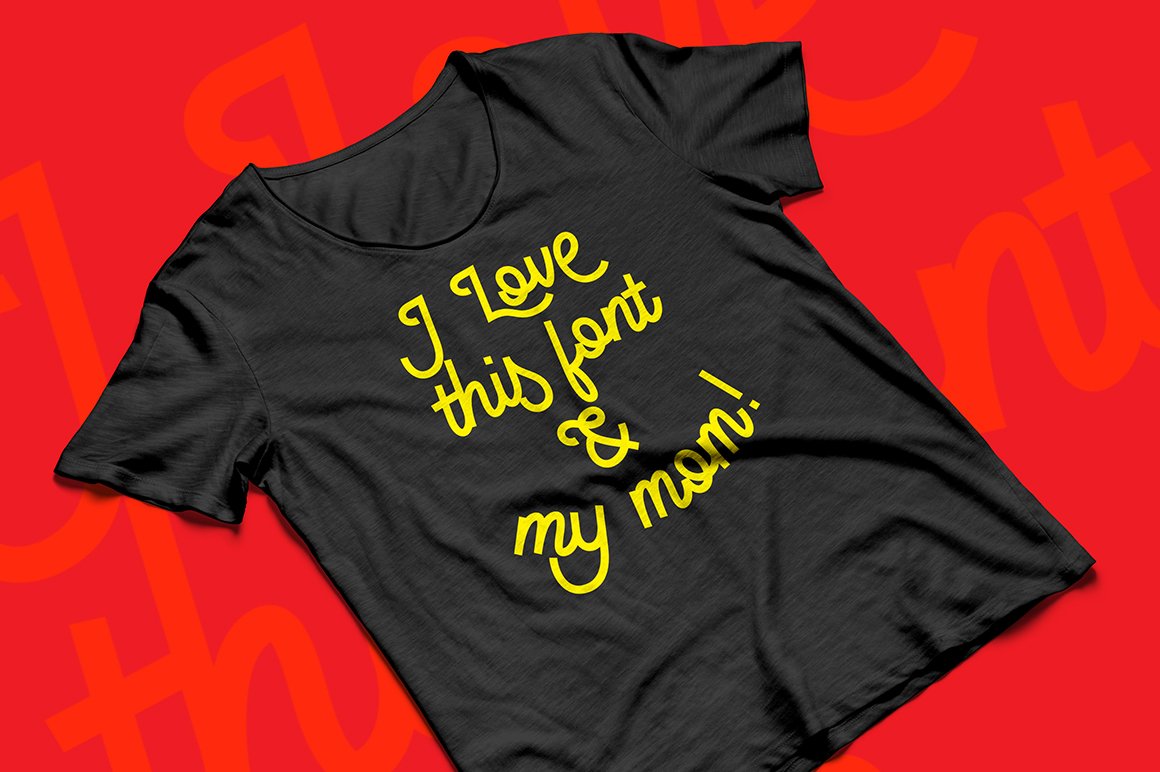 Black t-shirt with yellow script phrase on a red background.