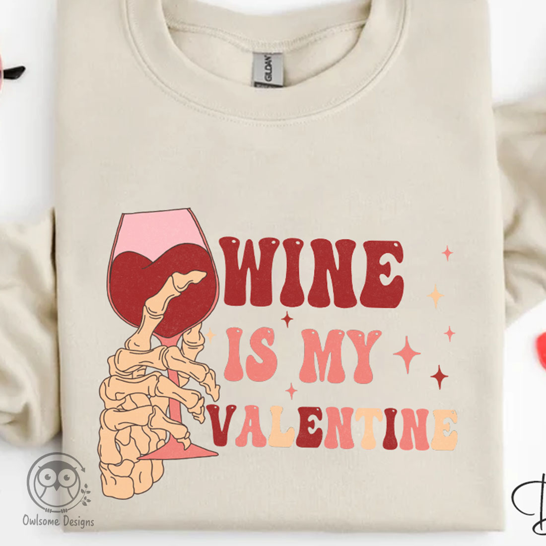Image of a t-shirt with a colorful print skeleton hands with a glass of wine.