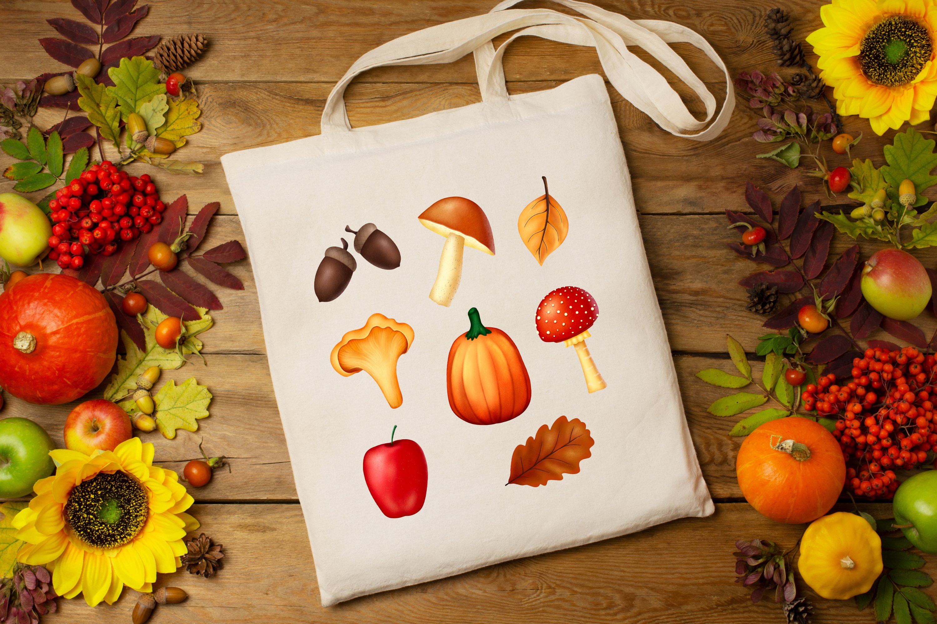 White shopping bag with fall illustrations on the wooden background with fall objects.