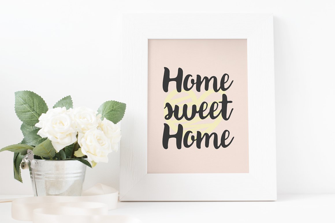 Black lettering "Home sweet Home" on a pink background in white frame.