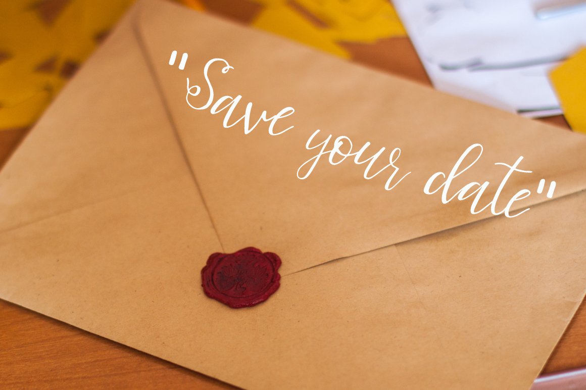 White lettering "Save your date" in bellahana script font on the background of envelope.