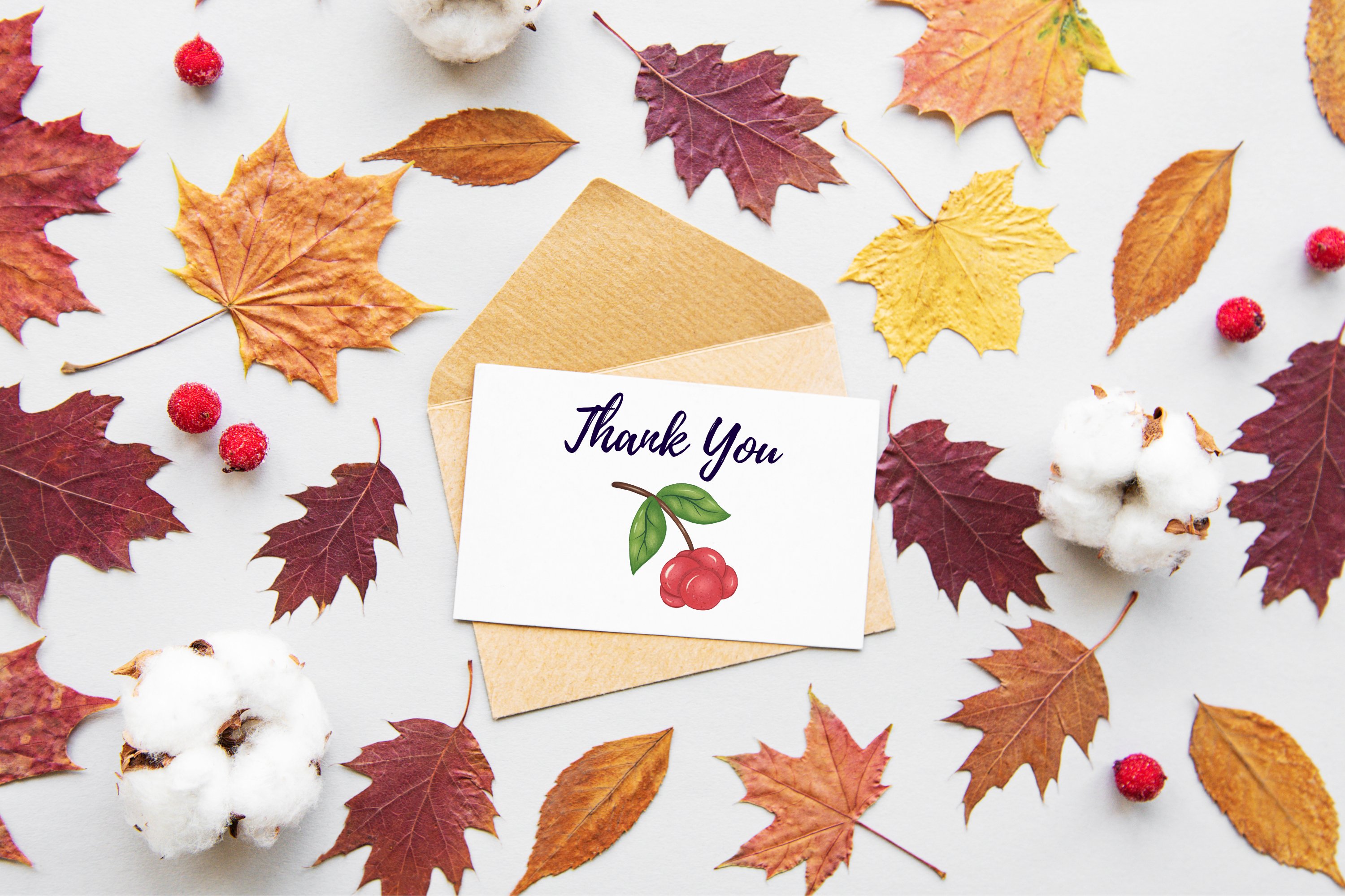 White card with black lettering "Thank you" and illustration on the craft envelope on a gray background with fall leaves.