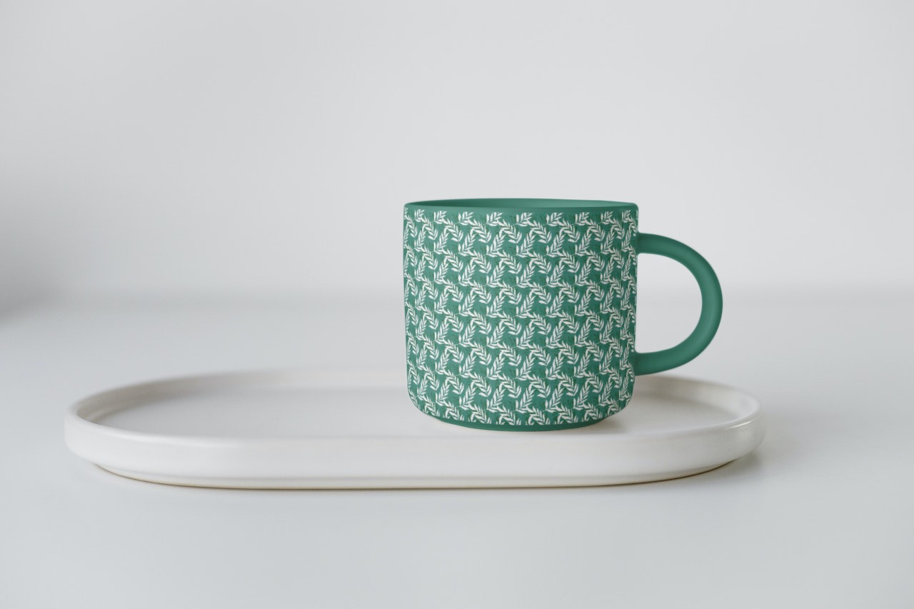 Stylish small turquoise cup with leaves print.