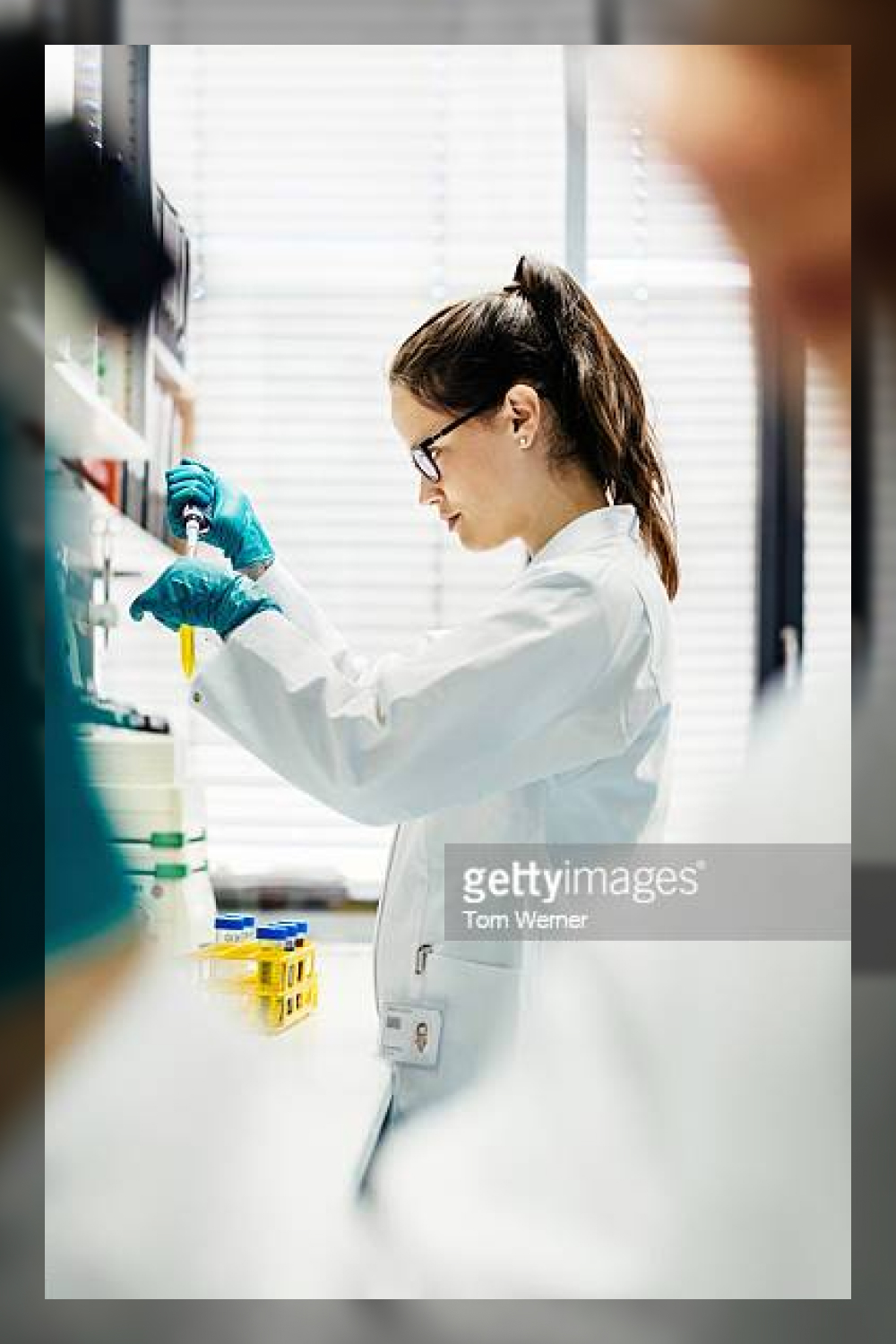 Female scientist using pipette in laboratory.