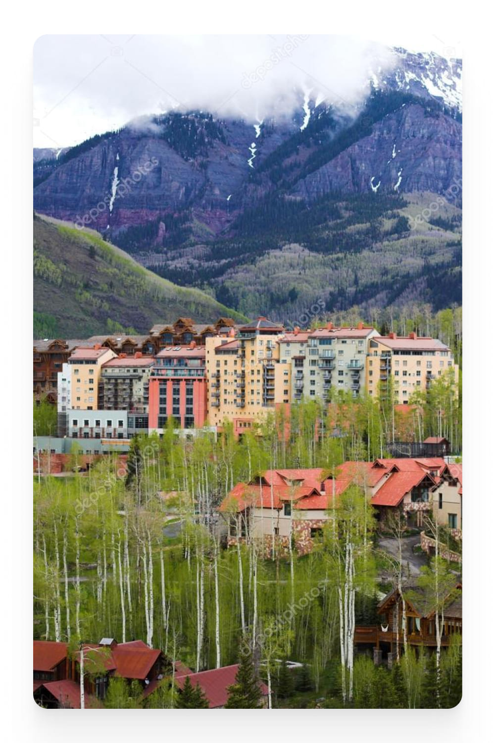Photo of multi-storey buildings against the backdrop of mountains.
