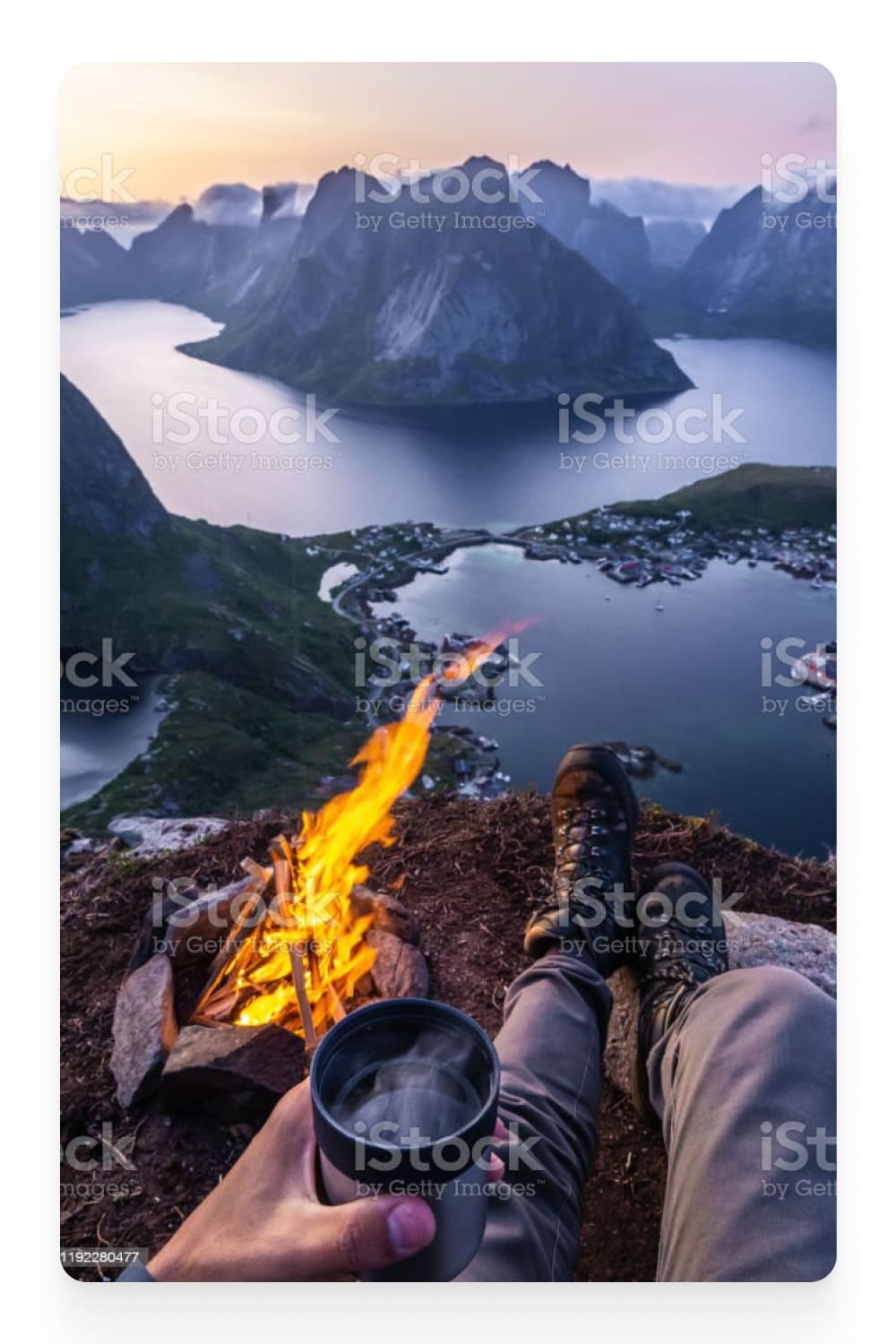 Photo of a guy sitting by the fire against the backdrop of fjords.
