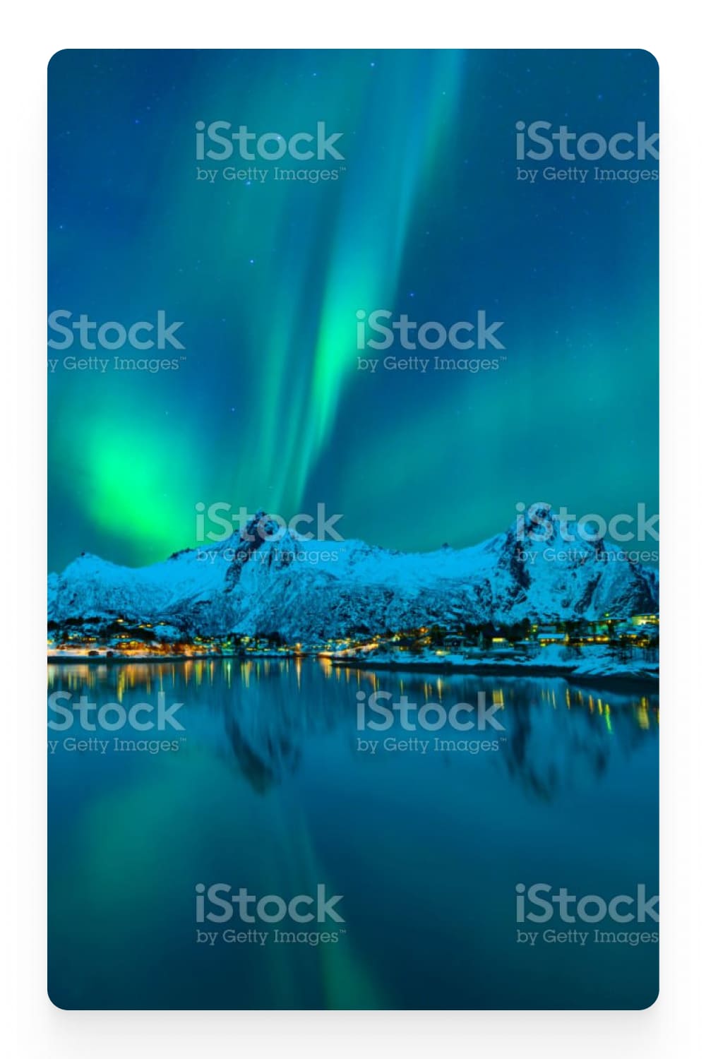 Photo of the aurora with mountains and a village by the sea in the background.