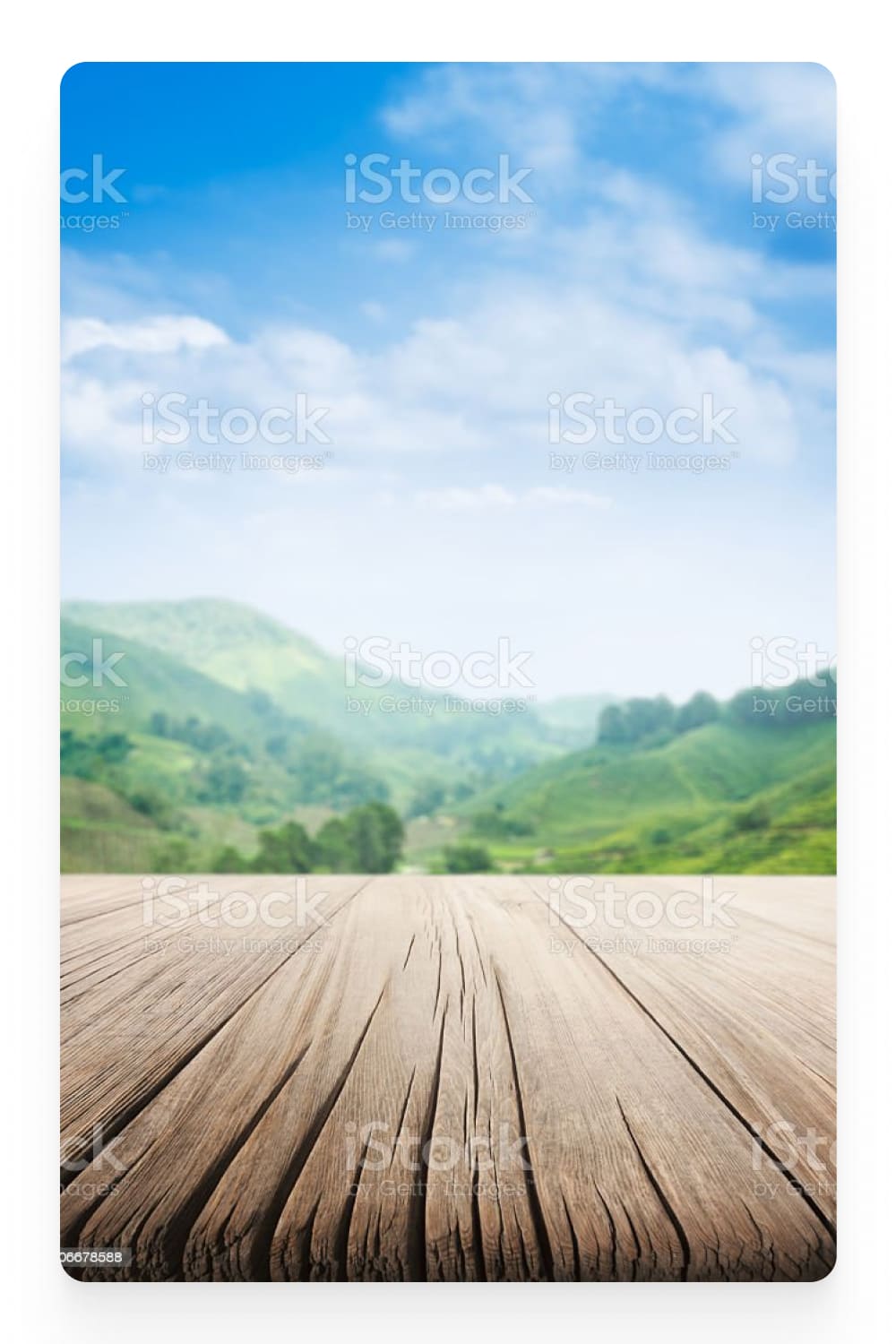 Photo of a wooden terrace and a view of the green hills.