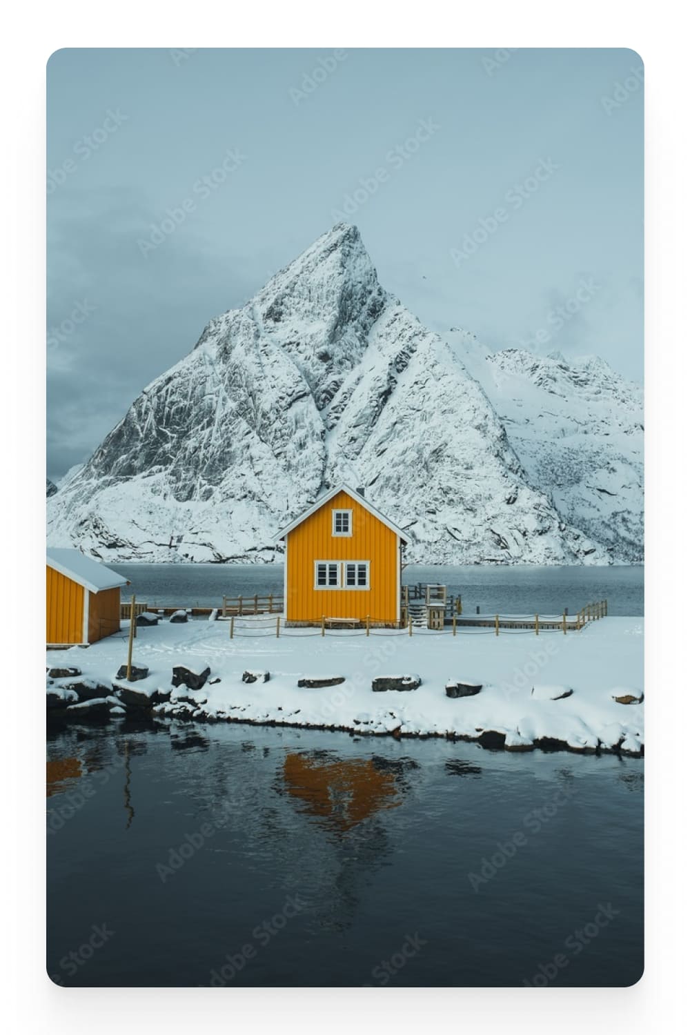 Photo of a yellow house on a snowy island.