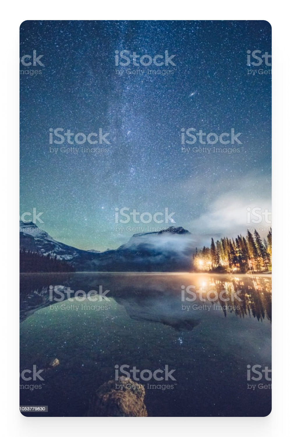 Photo of a calm lake in the mountains and a starry sky.