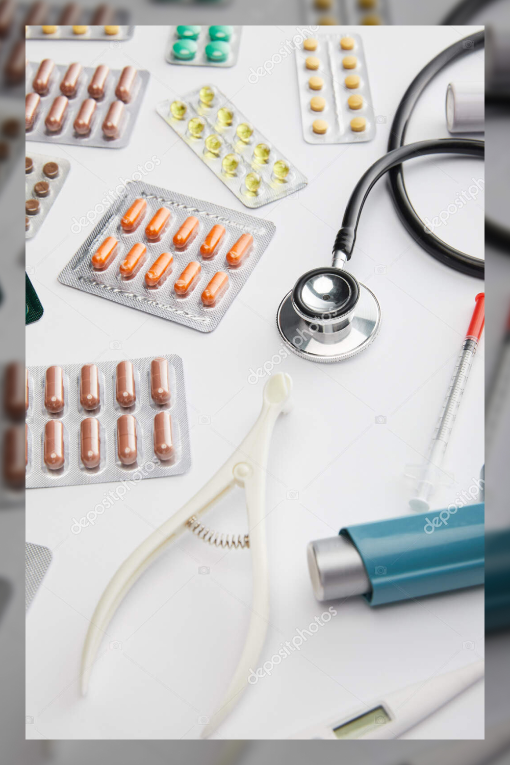 High angle view of medical objects and pills on white background.