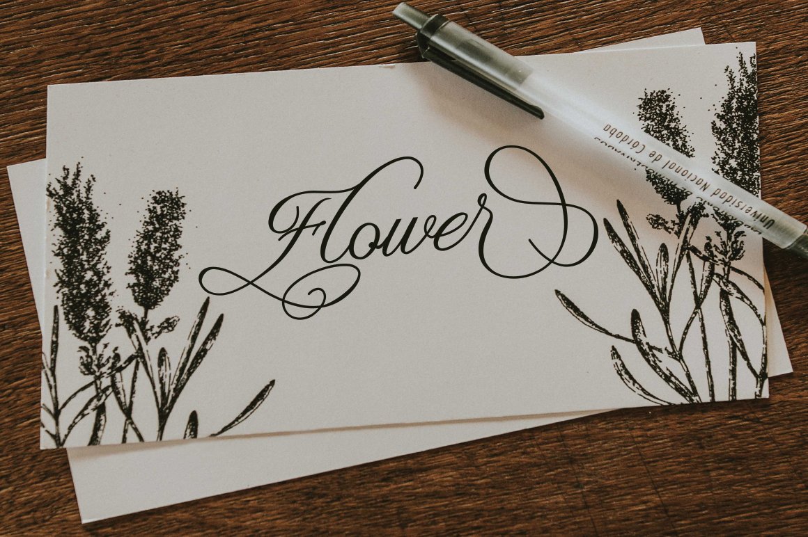 White card with black calligraphy lettering "Flower" on the table.