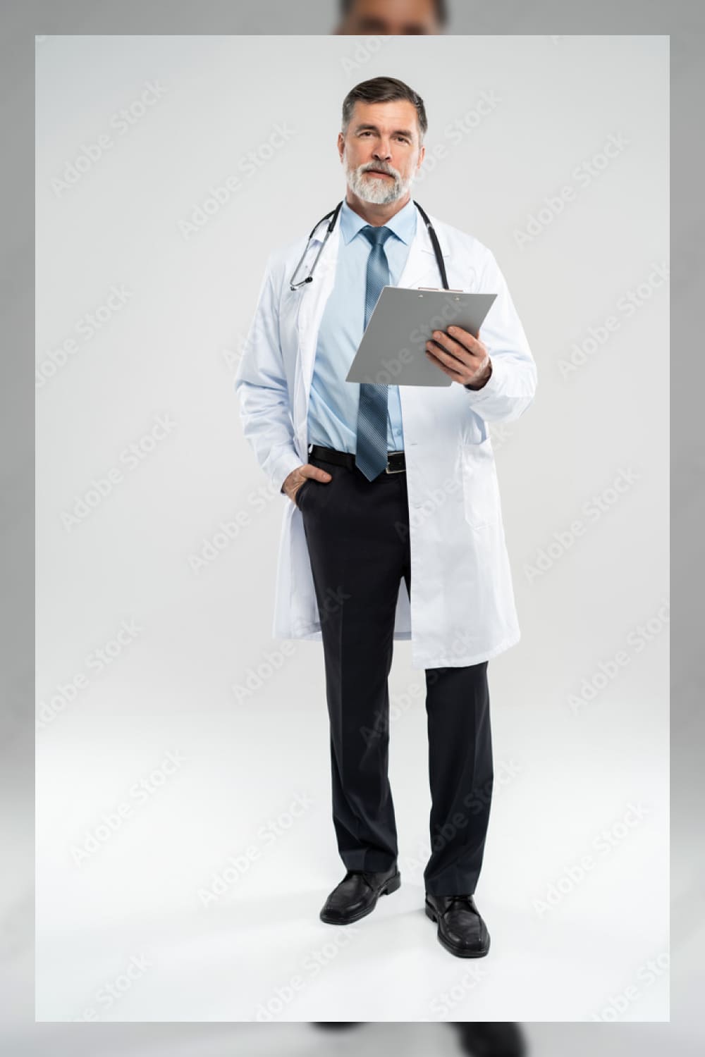 Full body picture of a mature doctor holding a notepad on white background.