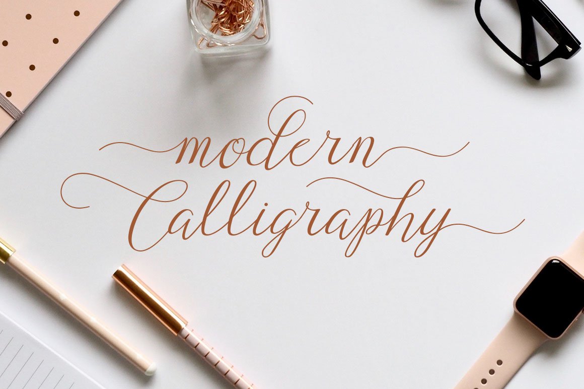 Brown calligraphy lettering on the table with different objects.