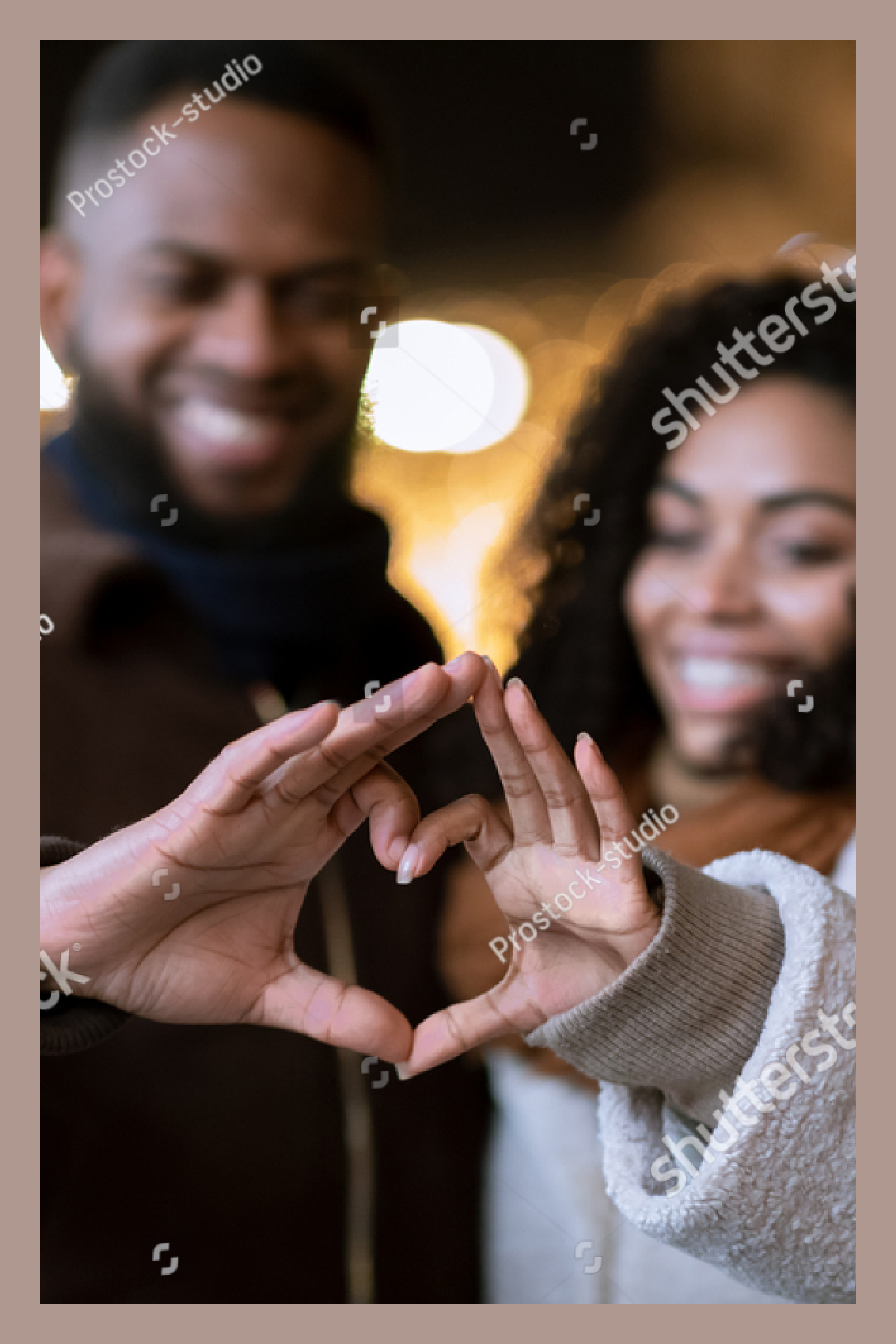 Couple making a heart by joining their fingers.