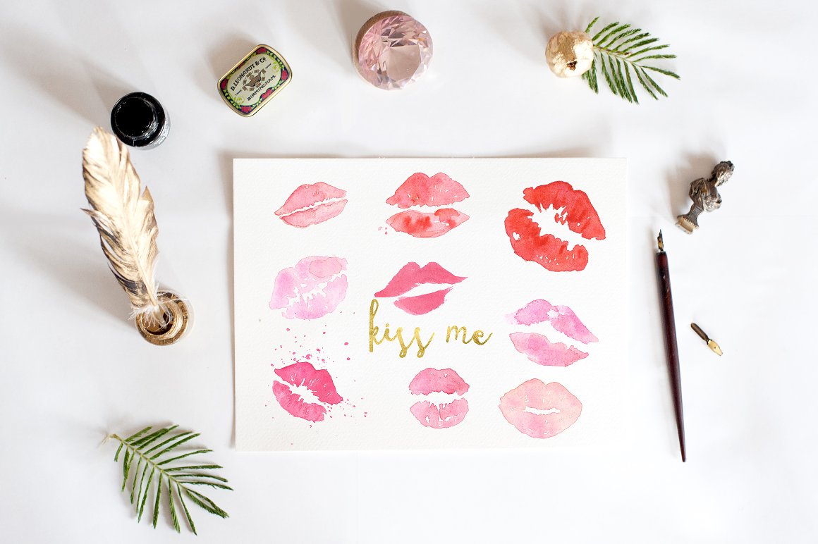 Drawing of 9 different watercolor lips and golden lettering "Kiss Me" on a white sheet.