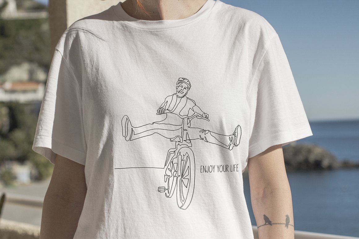 White t-shirt with black lettering and line art illustration of bicycle.