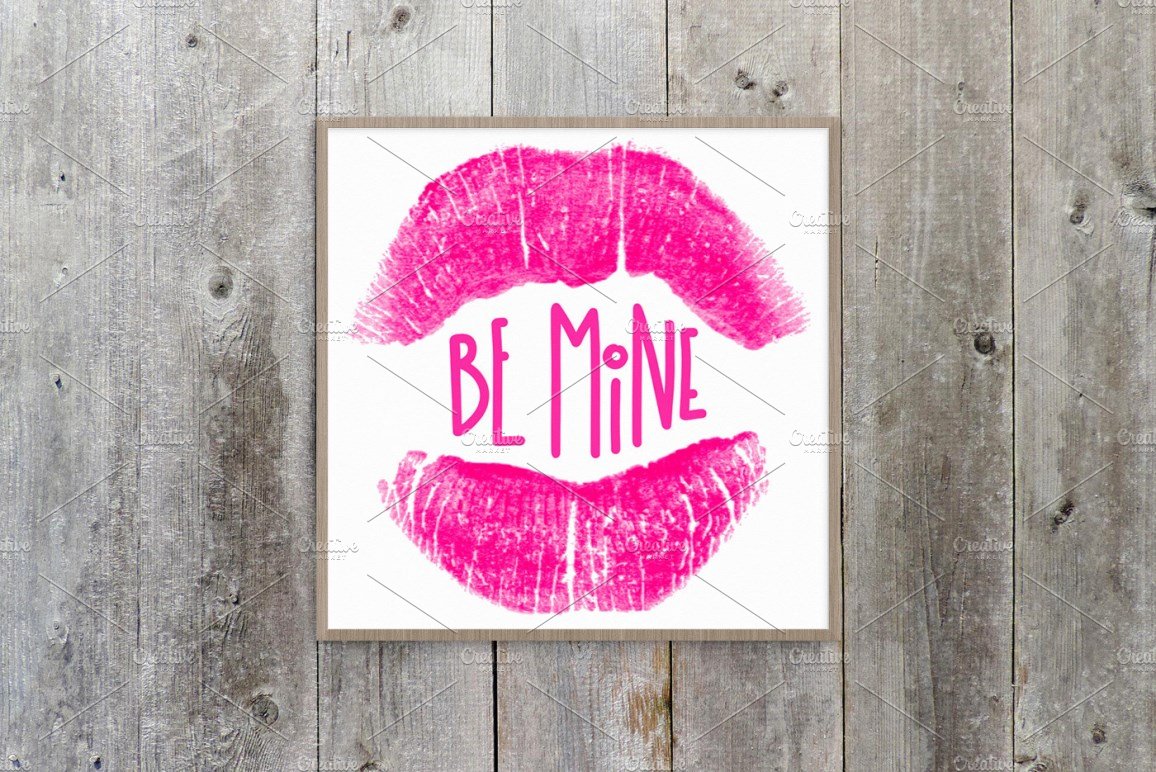 Poster with pink lettering "Be Mine" and pink lips on a white background in wooden frame.