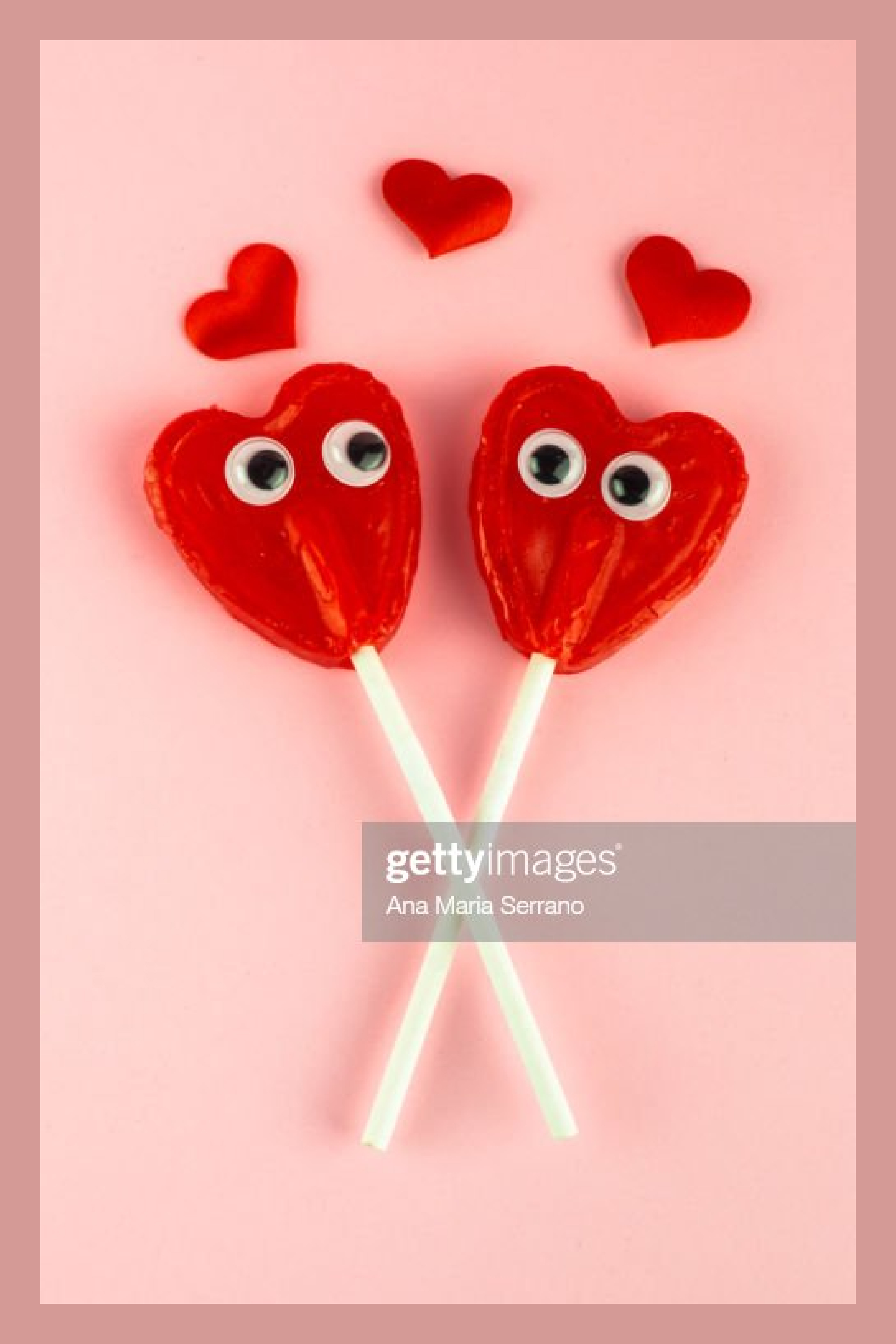 Two little heart-shaped lollipops looking at each other.