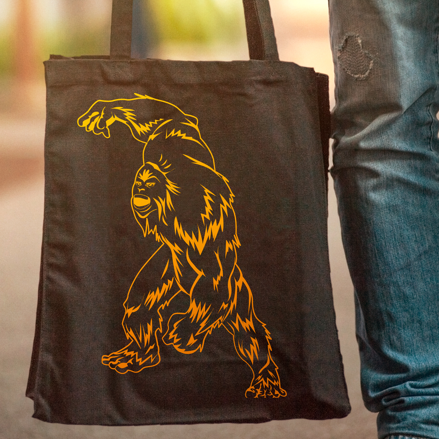 Person holding a black bag with a yellow gorilla on it.