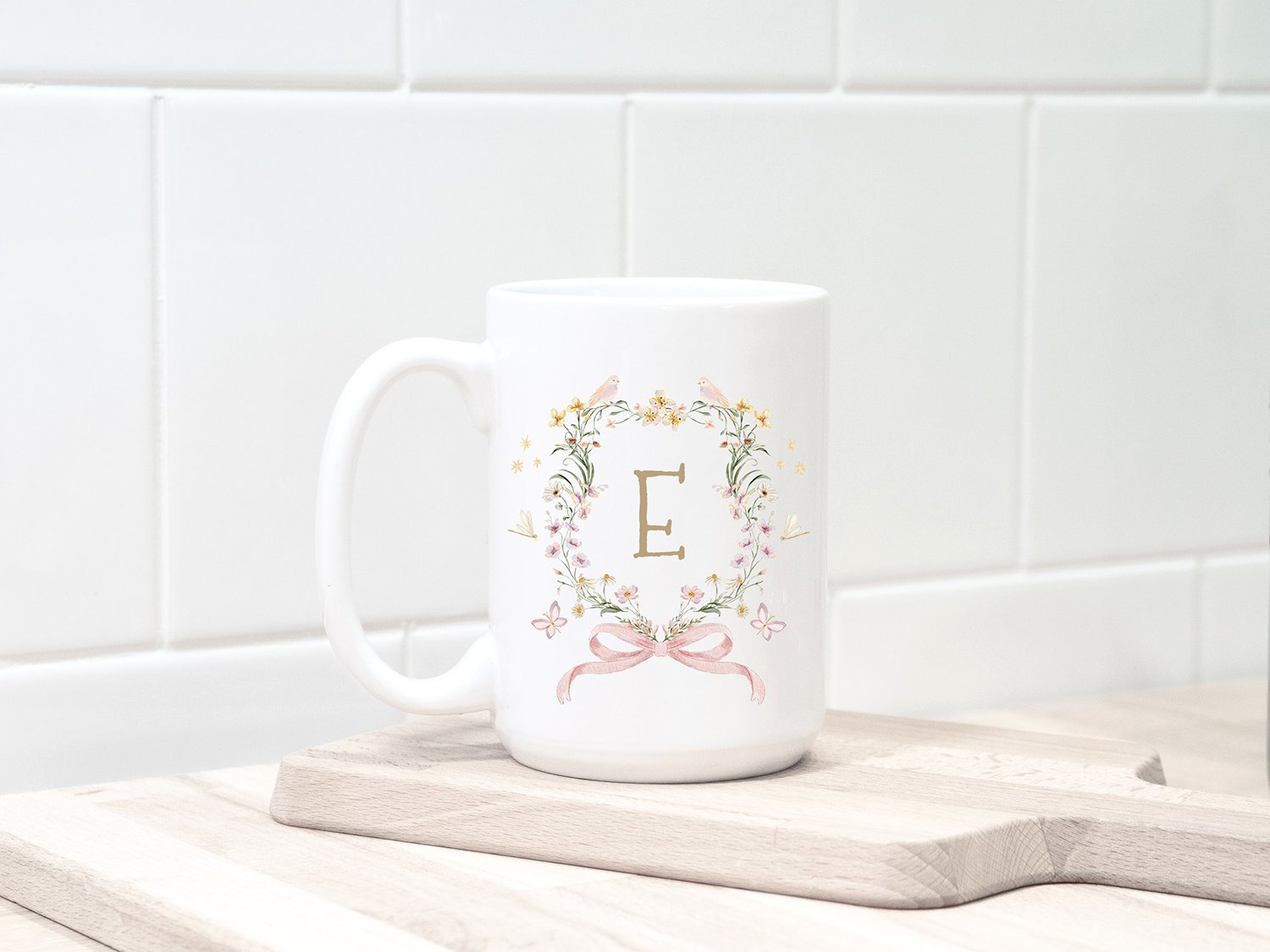 Big white tea cup with floral wreath and letter.
