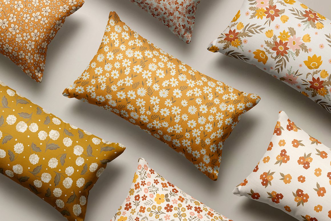 Pillows with warm florals patterns on a gray background.