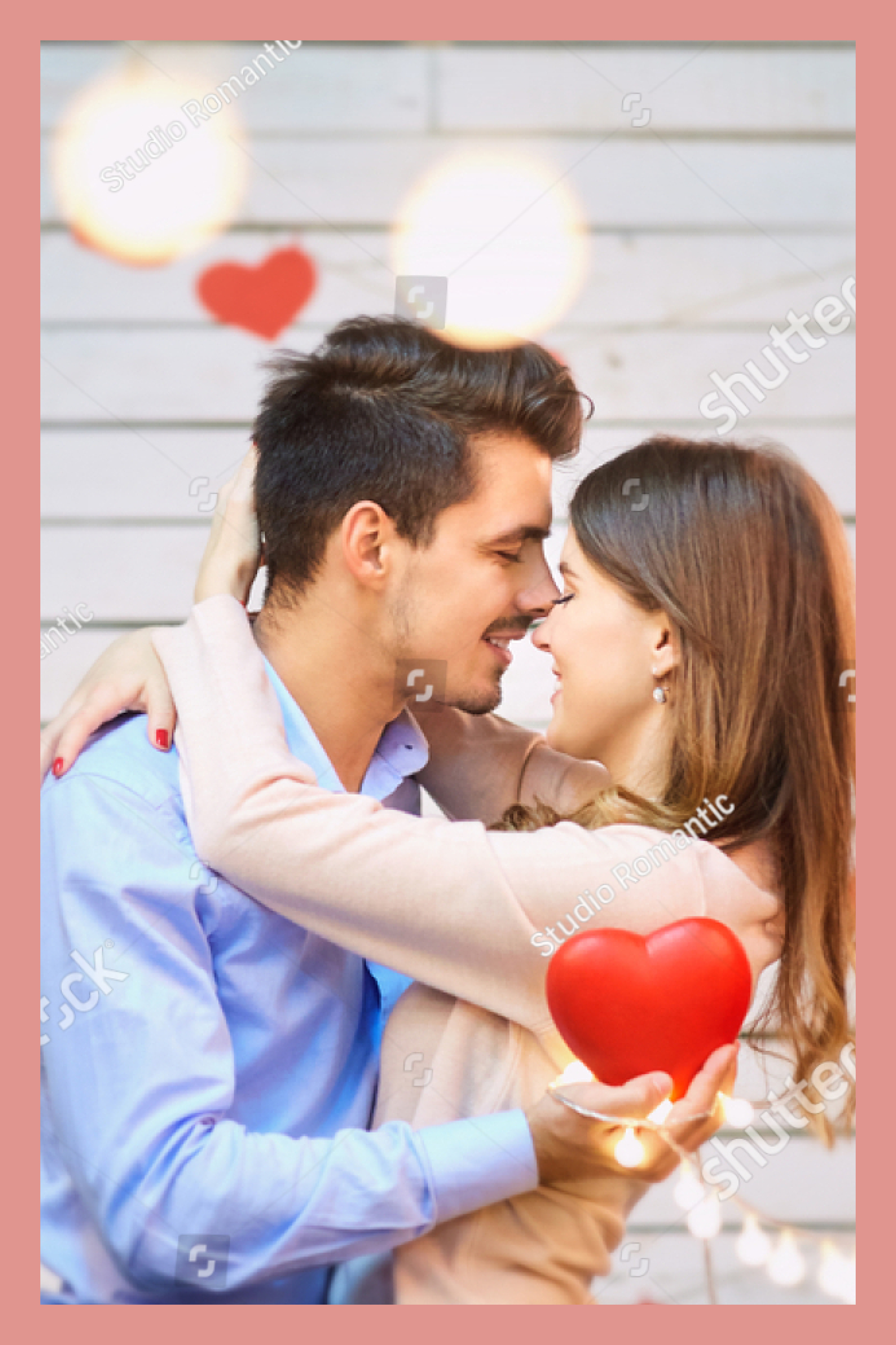 Couple in love hugging and holding a red heart.