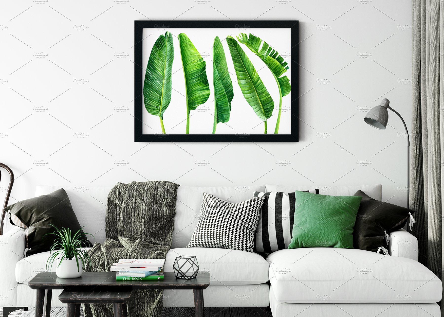 Living room with a white couch and a green plant on the wall.