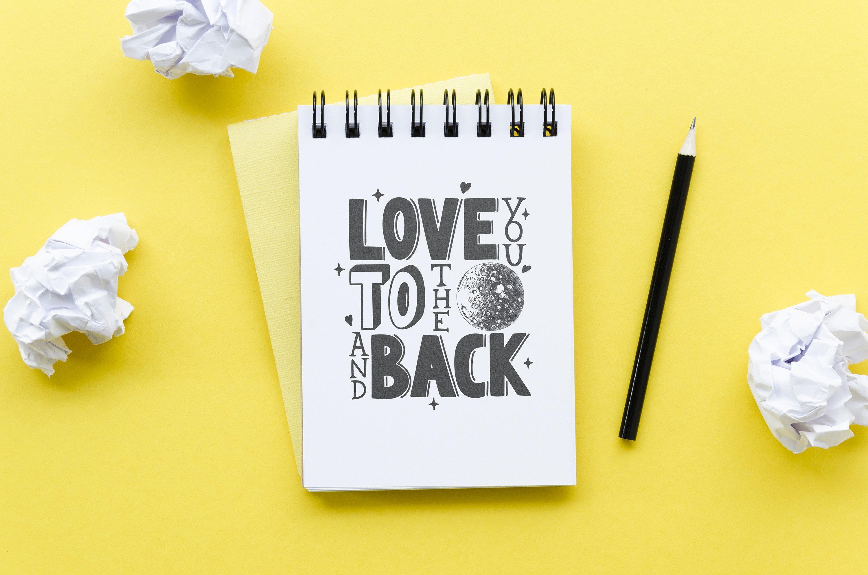 Spiral notebook with the words love you to the moon and back written on it.