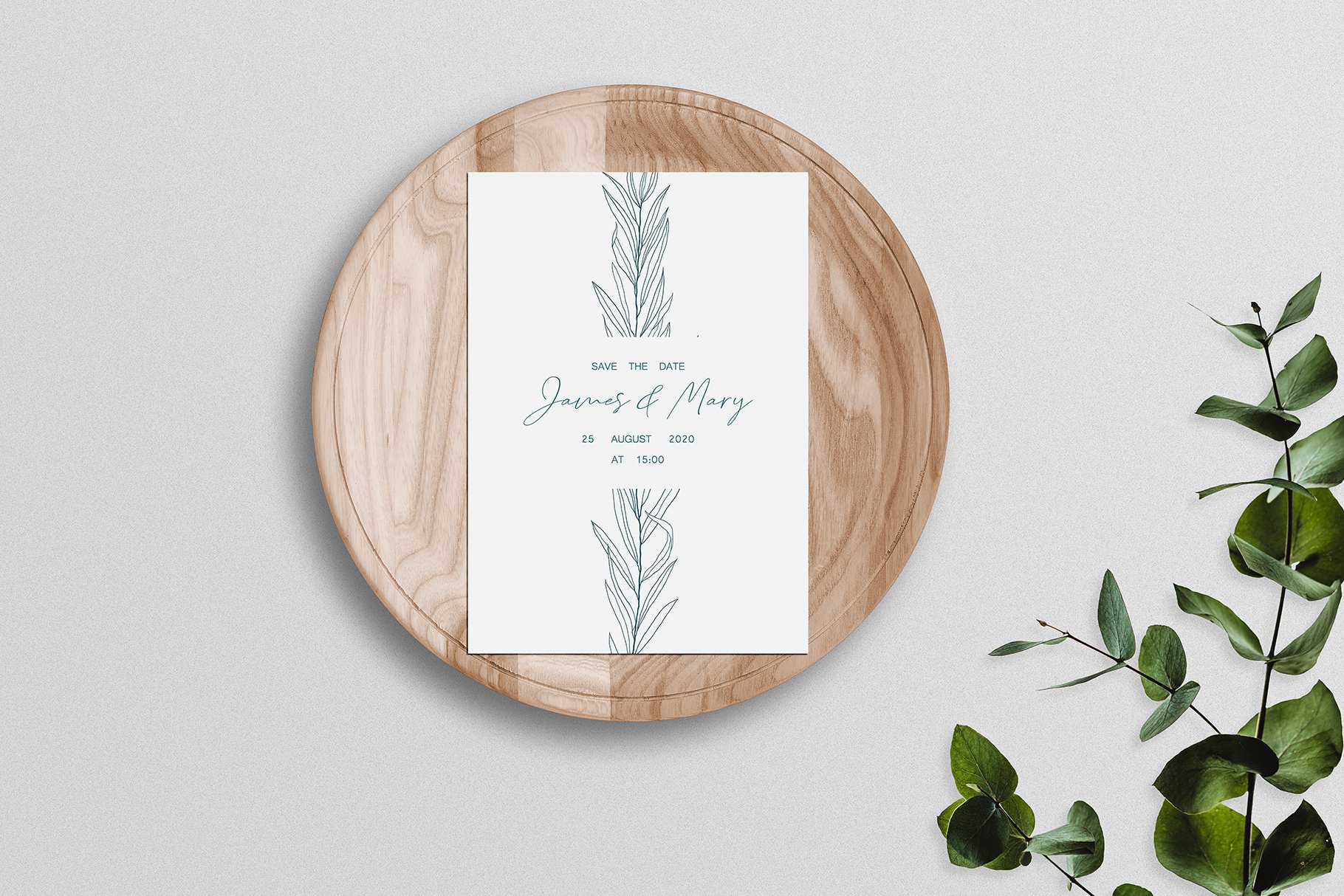 Wooden plate with a card on it next to a plant.