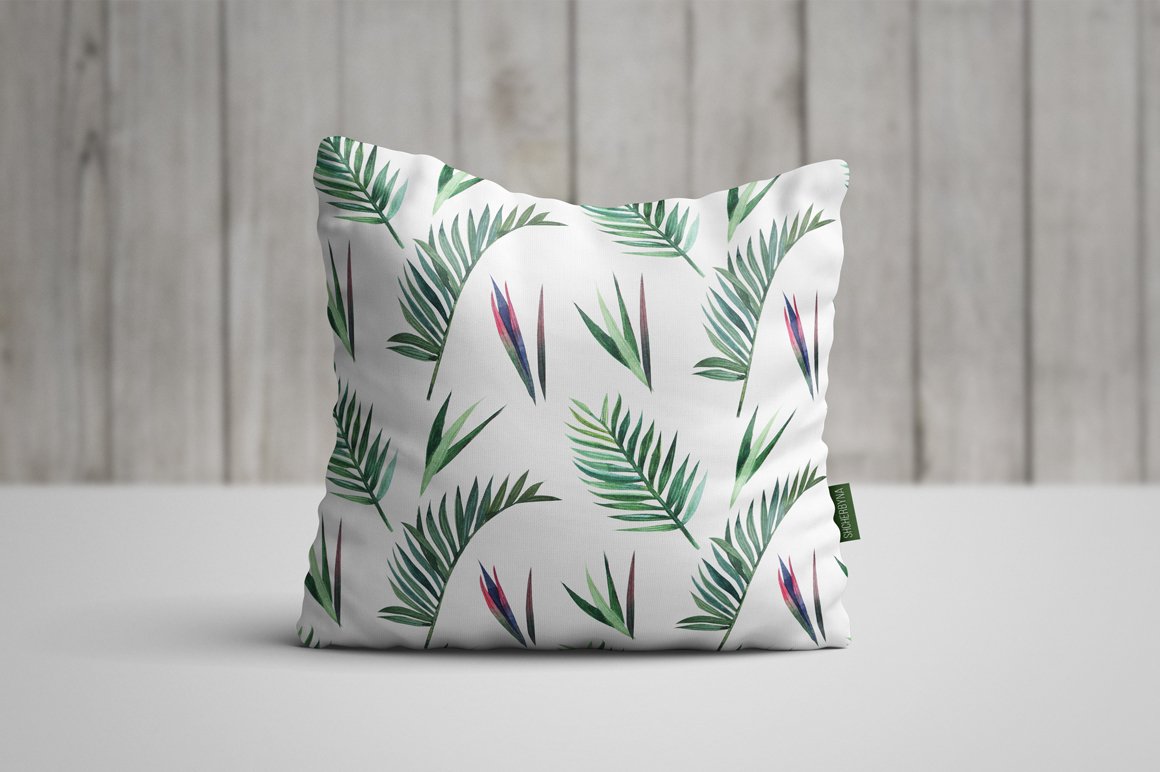 White pillow with green leaves on it.