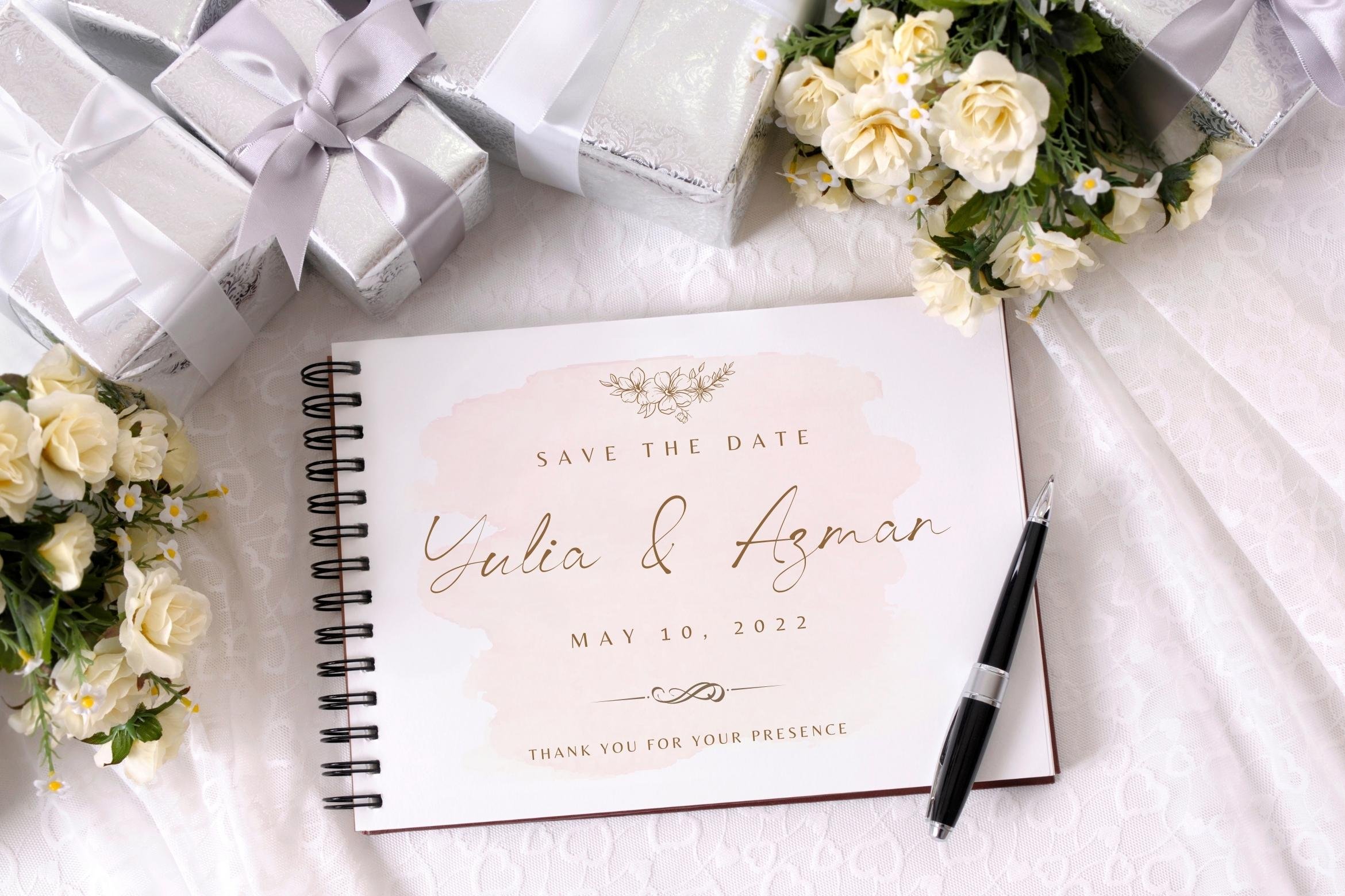 A wedding card and a pen on a table.