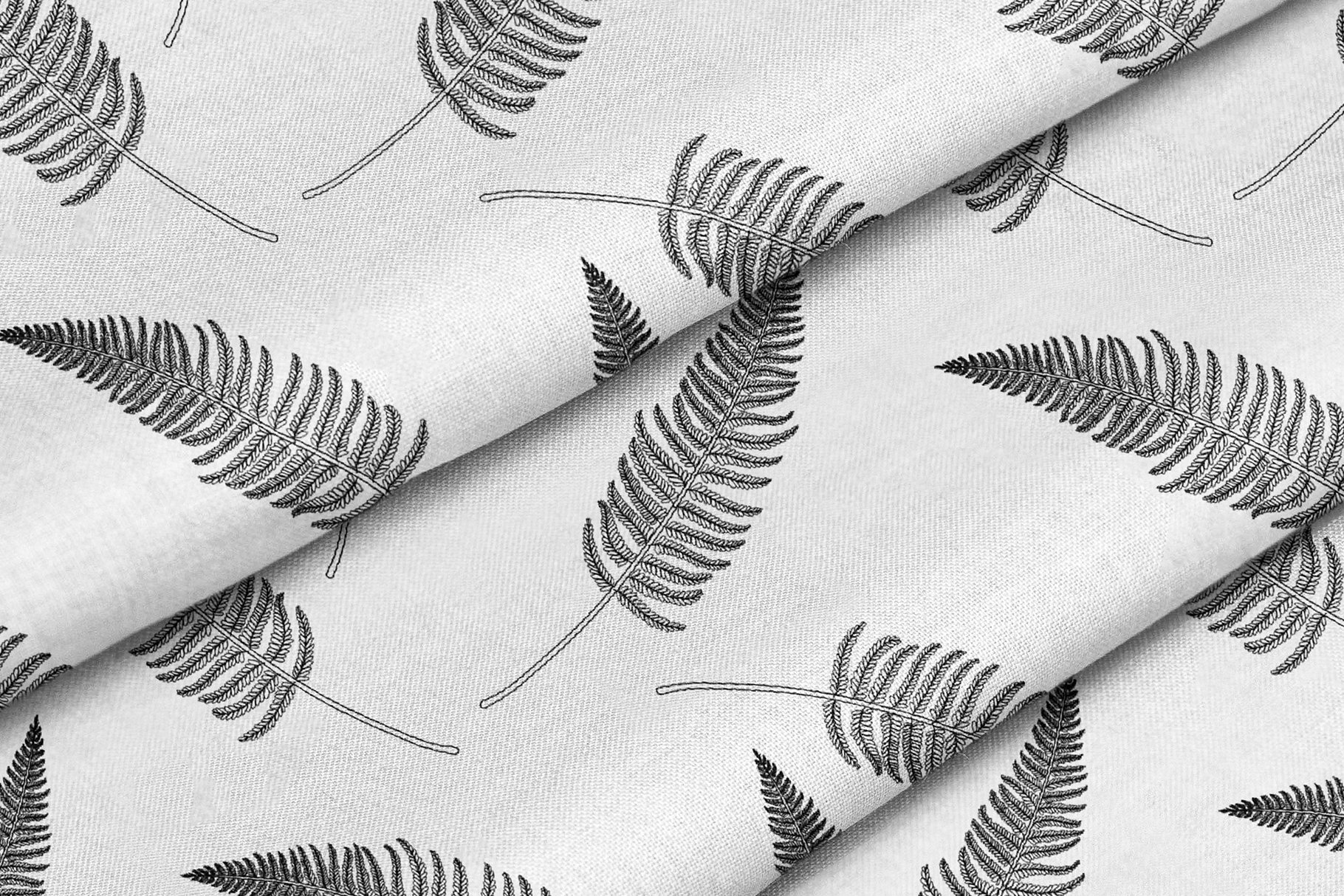 White fabric with black leaves on it.