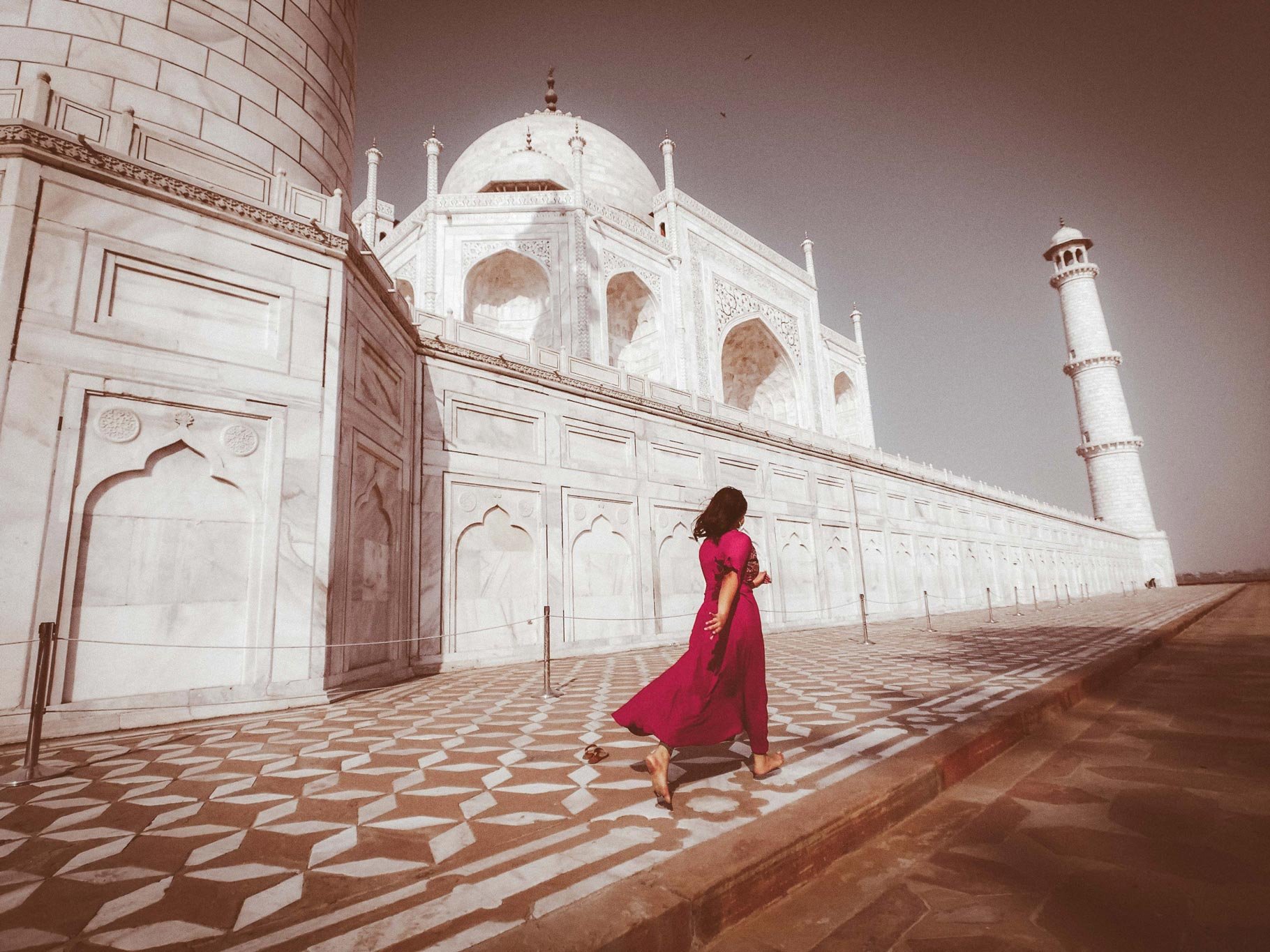 a woman in red passes the taj mahal 170