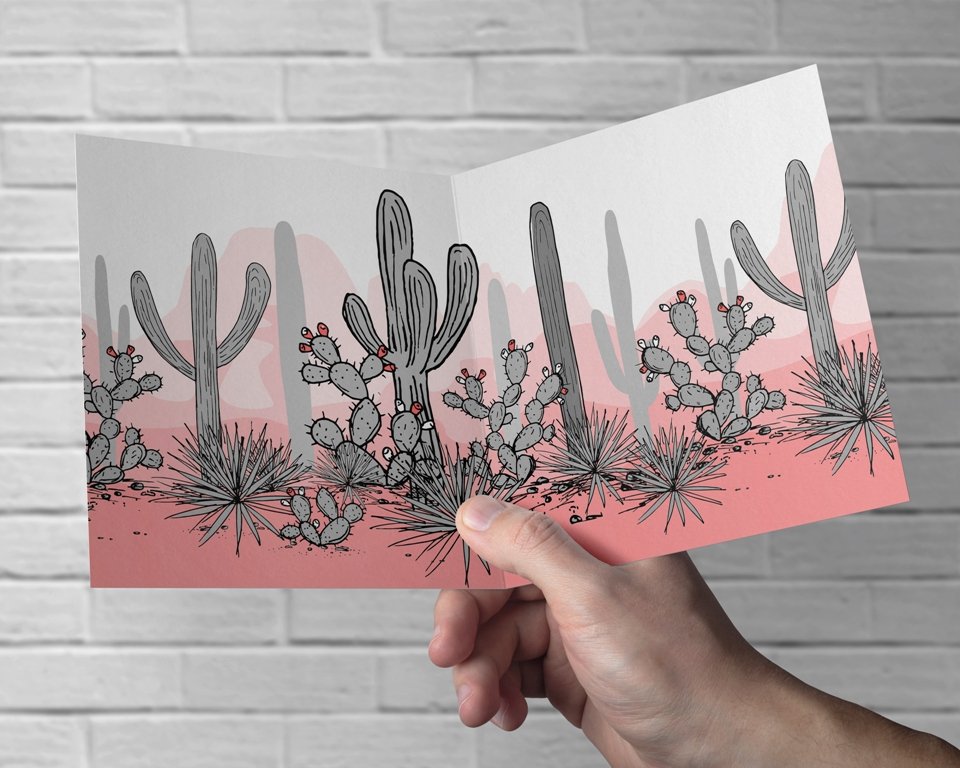 Person holding up a card with a cactus design on it.