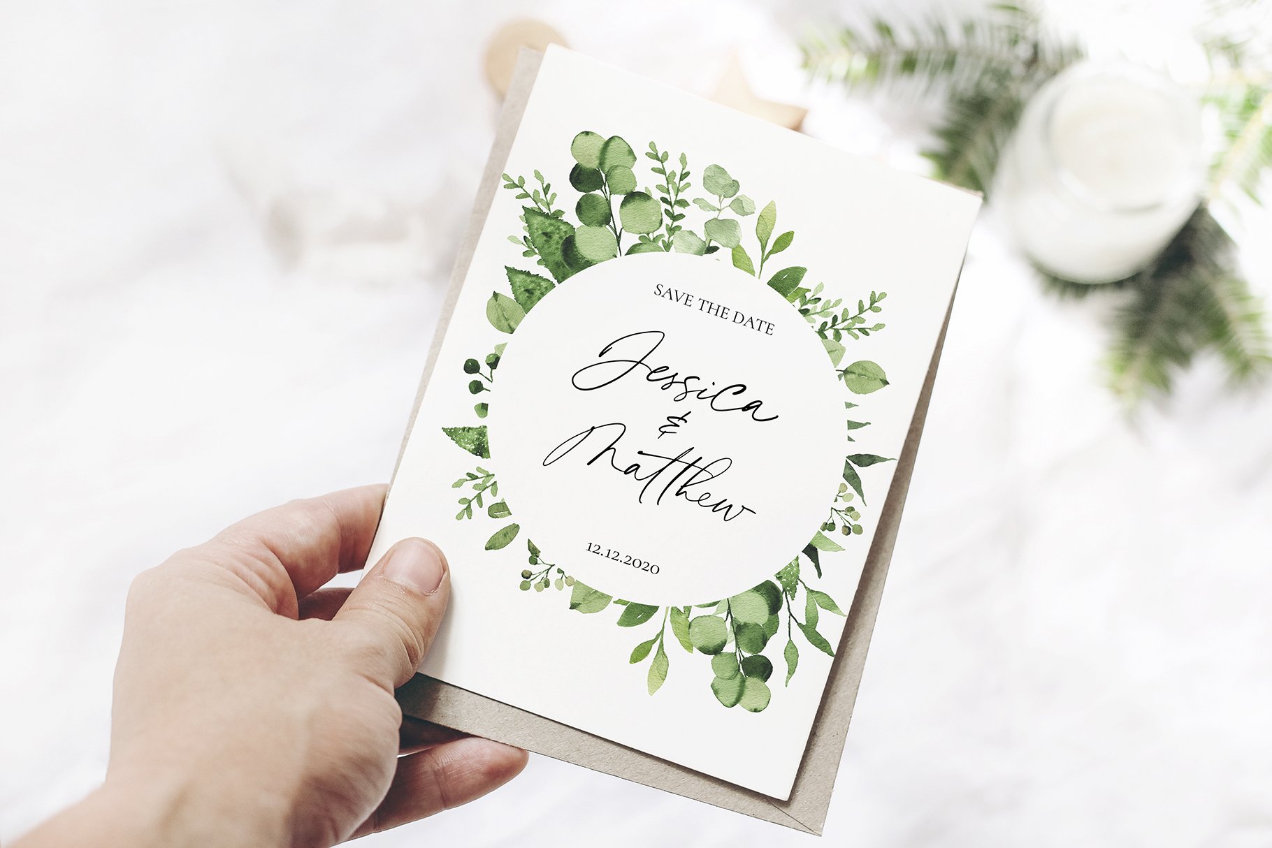 Hand holding a wedding card with greene on it.