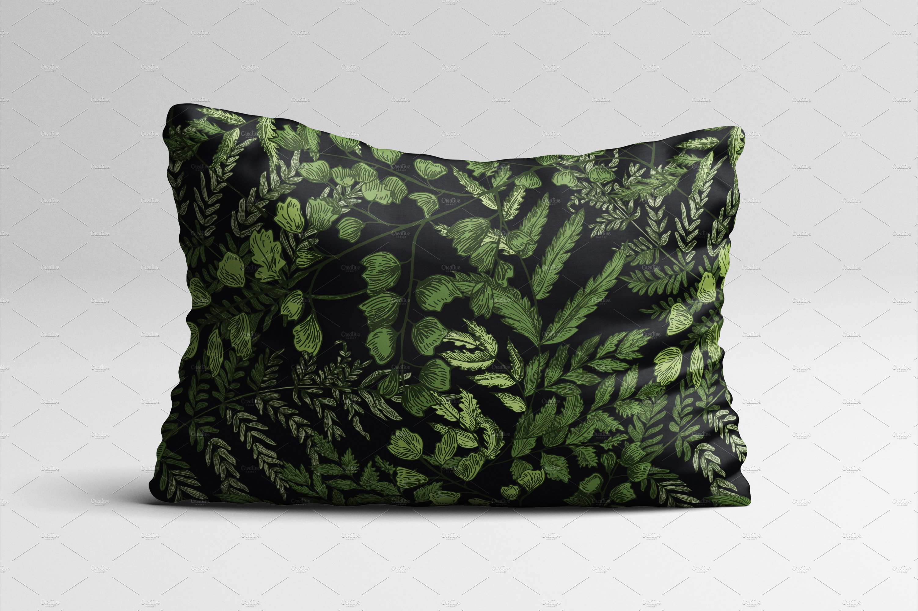 Black and green pillow with green leaves on it.