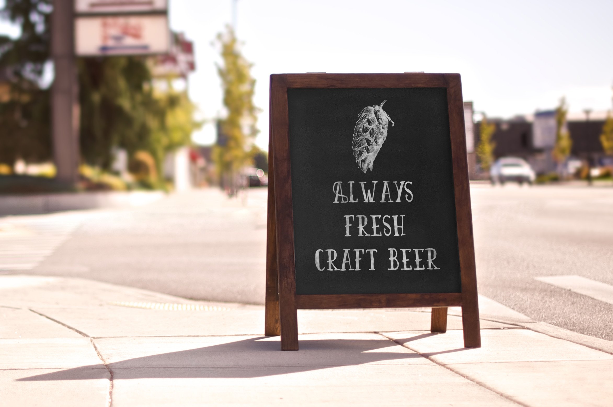 A sign on the side of the road that says always fresh craft beer.