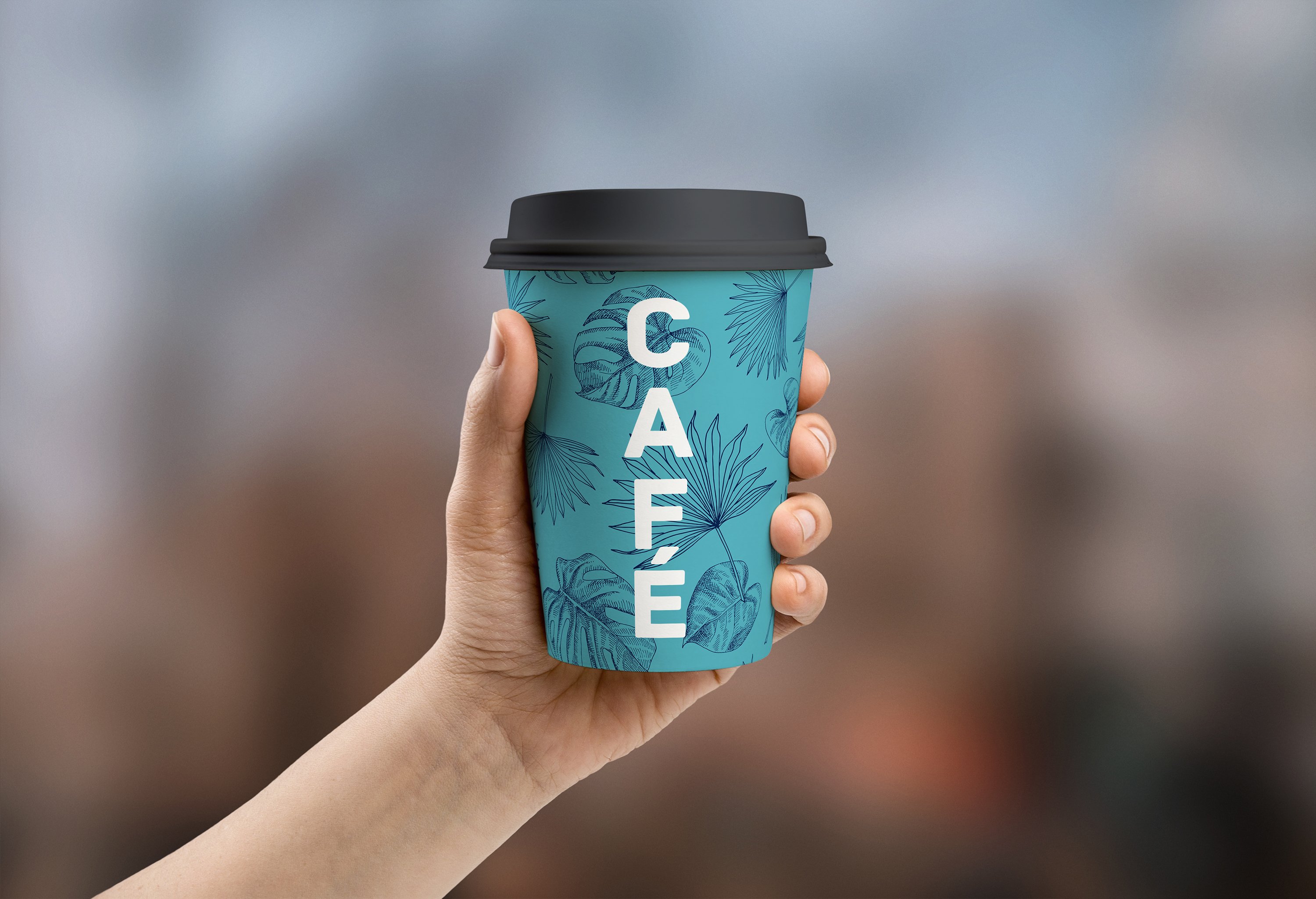 Hand holding a cup of coffee with the words cafe on it.