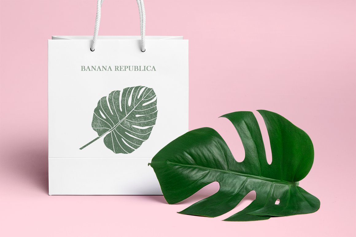 Green leaf next to a white shopping bag.