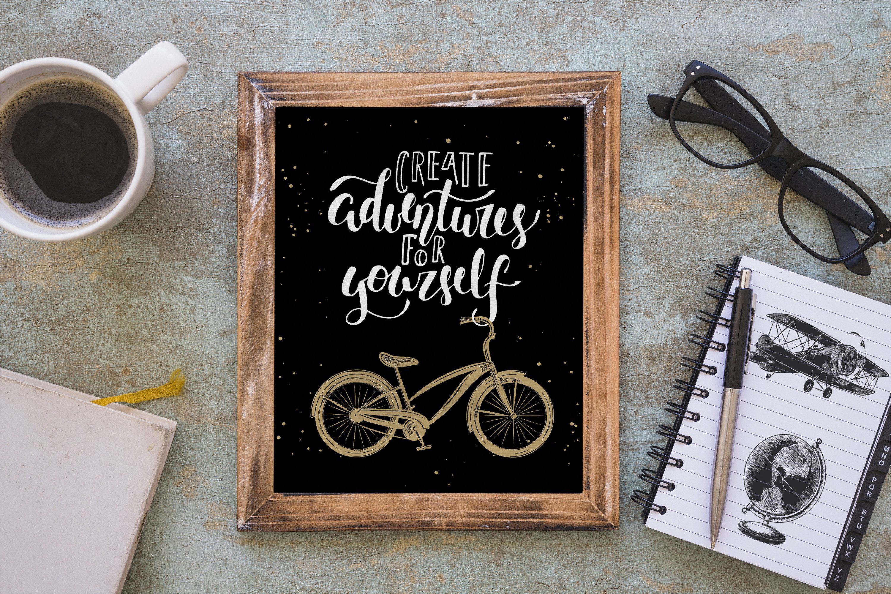 Picture frame with a bicycle on it next to a cup of coffee.