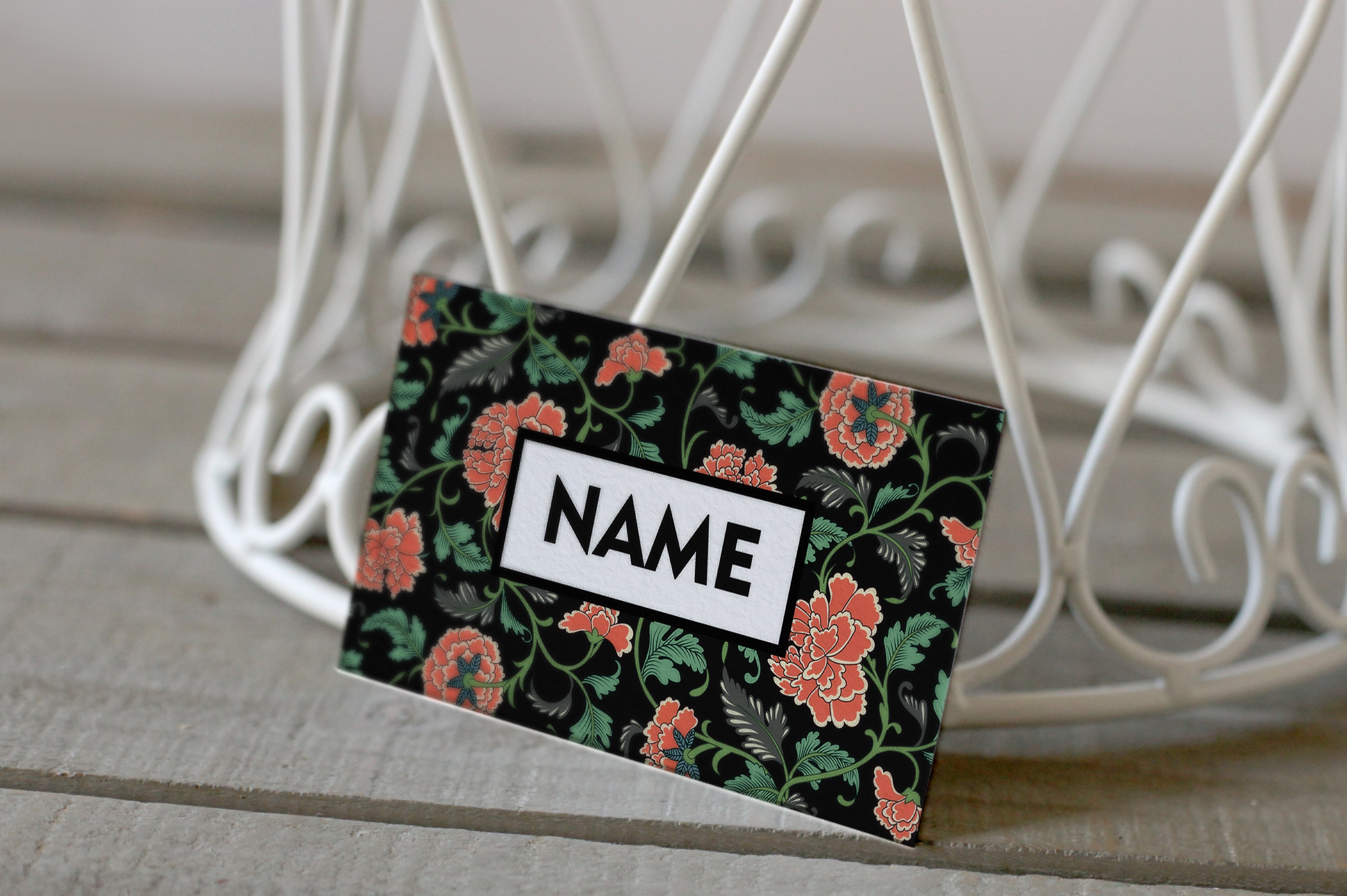 A name tag attached to a white wire holder.