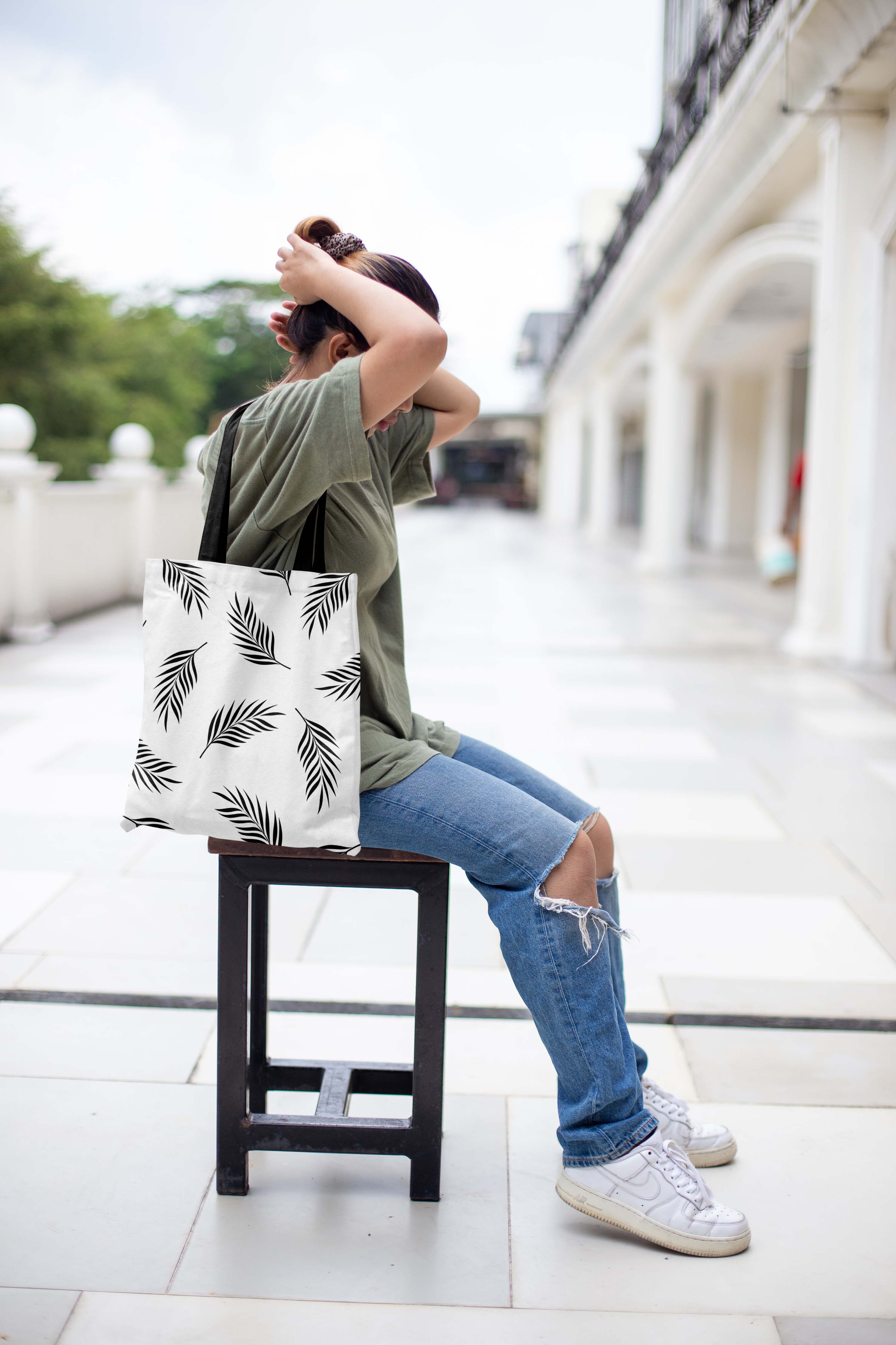 Woman sitting on a chair holding a bag.