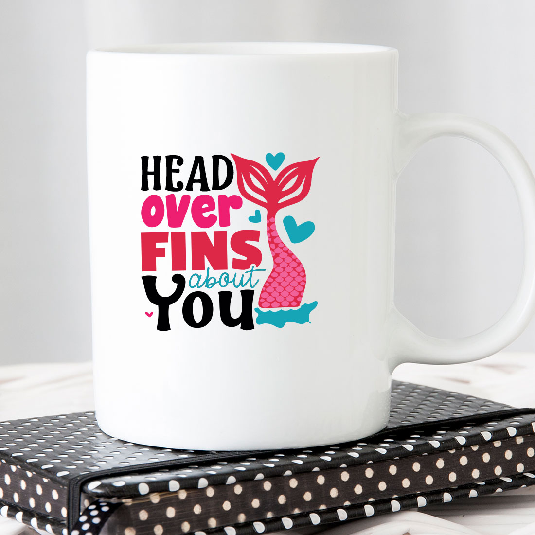 White coffee mug with the words head over fins about you.