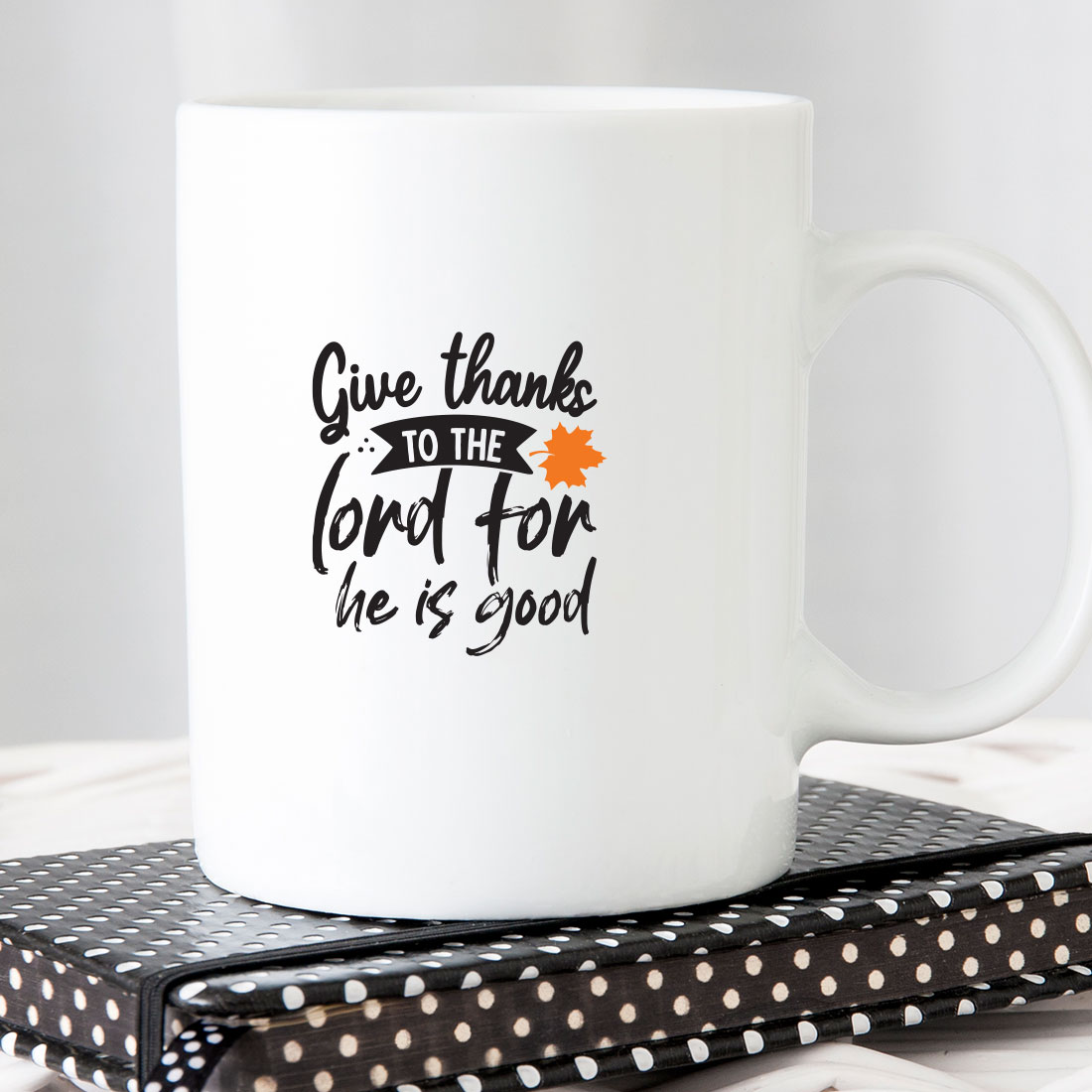 White coffee mug with the words give thanks to the lord for he is good.