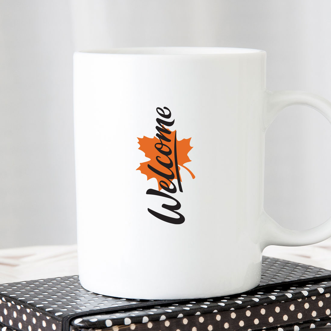 White coffee mug sitting on top of a stack of books.