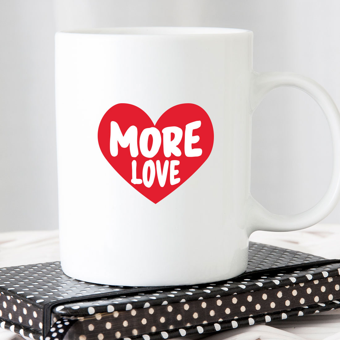 White coffee mug with the words more love printed on it.