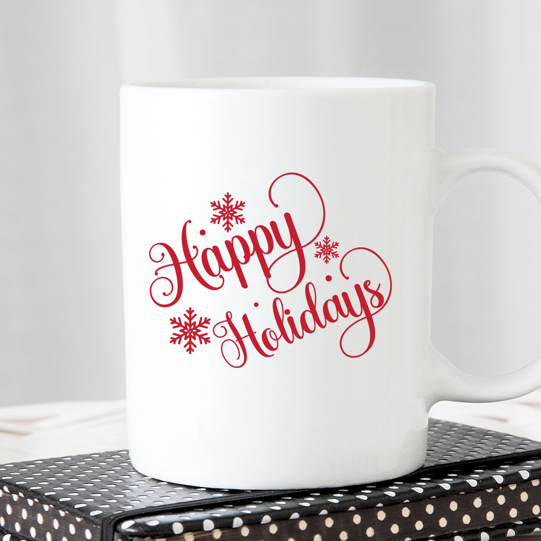 White coffee mug sitting on top of a stack of books.